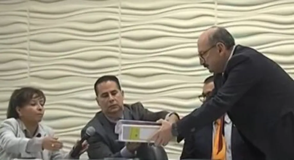 El procurador del Estado, Hugo León La Faye, entrega los documentos a la subcontralora, Sonia Velásquez. Foto: Captura de imagen