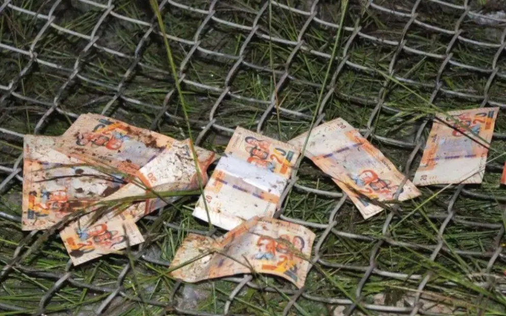 Algunos de los billetes que cayeron del avión accidentado en El Alto. Foto: APG