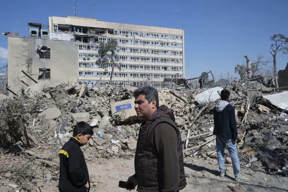 Varias personas caminan cerca de una zona alcanzada por los bombardeos israelíes-estadounidenses en los alrededores del Gran bazar de Teherán. Foto: EFE 