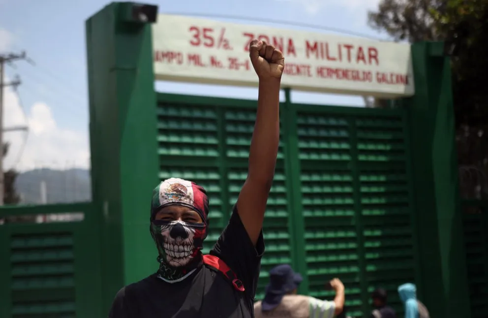 Un estudiante alza su brazo durante protestas frente a un cuartel militar para exigir justicia por los 43 normalistas desaparecidos de Ayotzinapa, en Chilpancingo, estado de Guerrero (México). Foto: Imagen de archivo/EFE