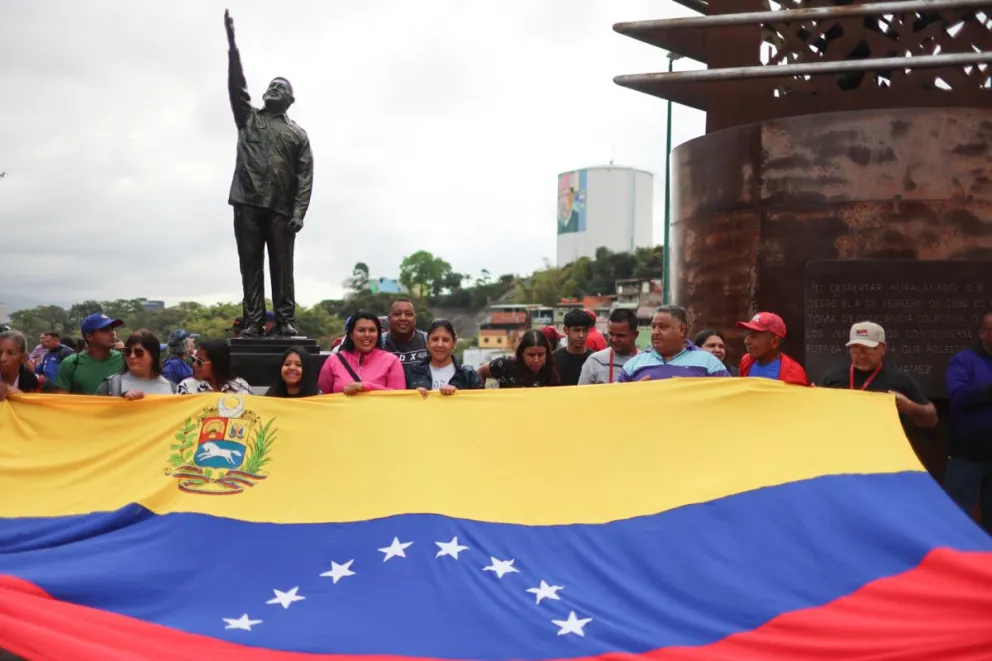 Fotografía de archivo que muestra a personas junto a la estatua del fallecido presidente de Venezuela Hugo Chávez, en Caracas (Venezuela). Foto: EFE