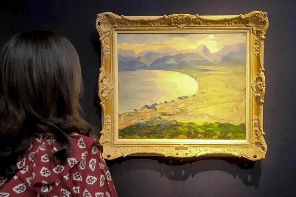 Una mujer observa "Escena de la costa de la Ribera", obra de 1935 de de Winston Churchill. Foto: EFE 