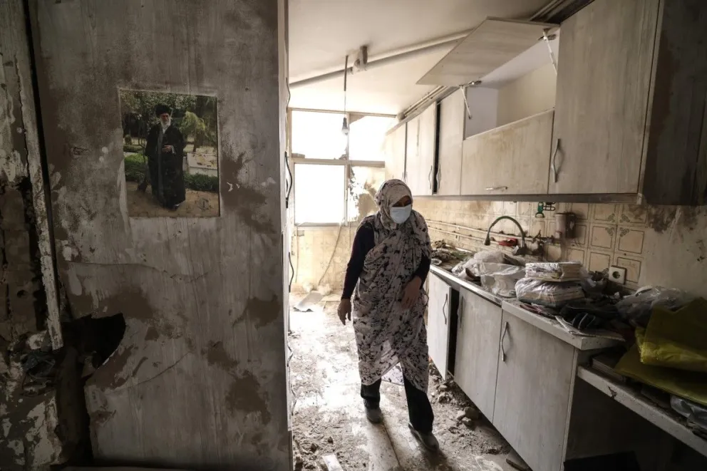 Una mujer iraní camina por la cocina destruida de una casa tras un ataque militar en la capital iraní, Teherán, el 15 de marzo de 2026. Foto: AFP