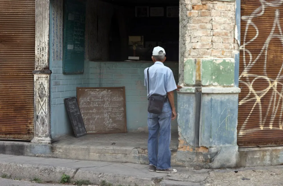 Una persona observa una lista de productos en una bodega este lunes, en La Habana (Cuba). Foto: EFE
