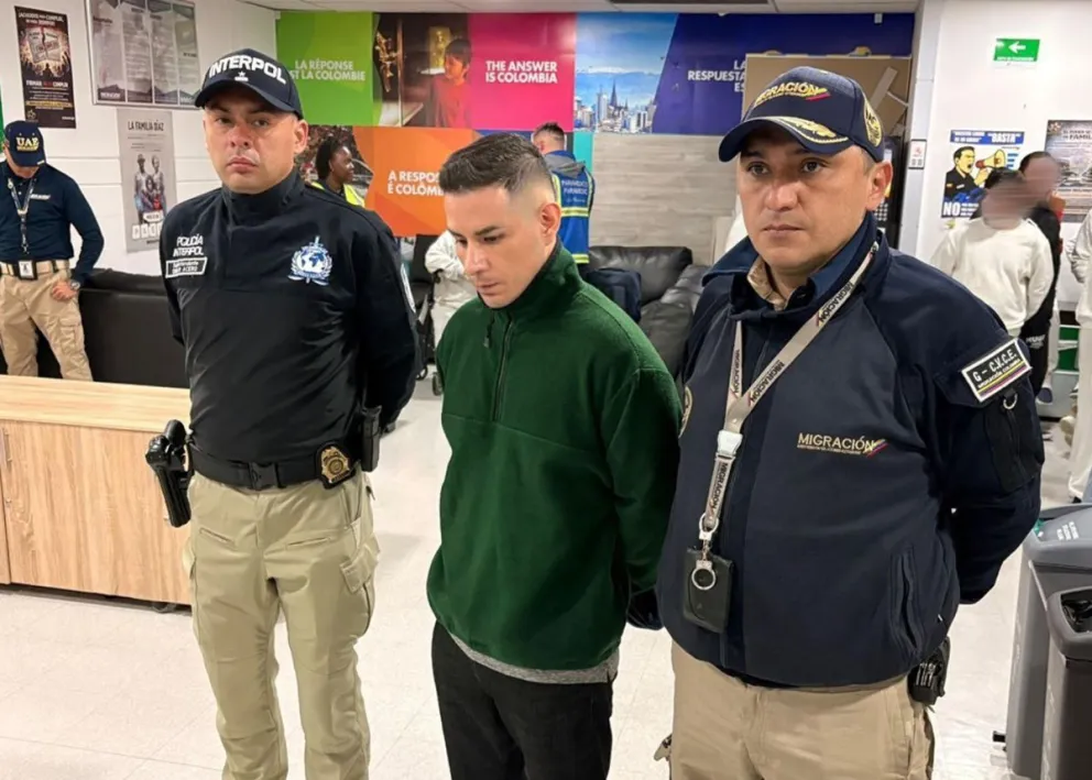 Fotografía cedida por Migración Colombia que muestra a Ángel Esteban Aguilar Morales, alias Lobo Menor (c), siendo detenido por funcionarios de Migración Colombia este miércoles, en Bogotá (Colombia). Foto: EFE