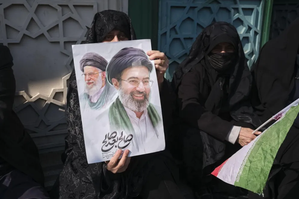 Un mujer porta una pancarta con la imagen del nuevo líder supremo de Irán, Mojtaba Jameneí, y su padre y antecesor en el cargo. Foto: EFE 