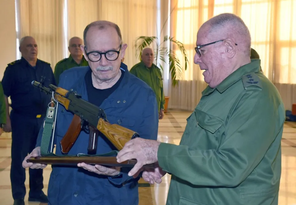 Fotografía cedida por Estudio Revolución que muestra al cantautor cubano Silvio Rodríguez (i) sosteniendo un fusil junto al ministro de las Fuerzas Armadas Revolucionarias de Cuba, Álvaro López Miera, este viernes, en La Habana (Cuba). Foto: EFE