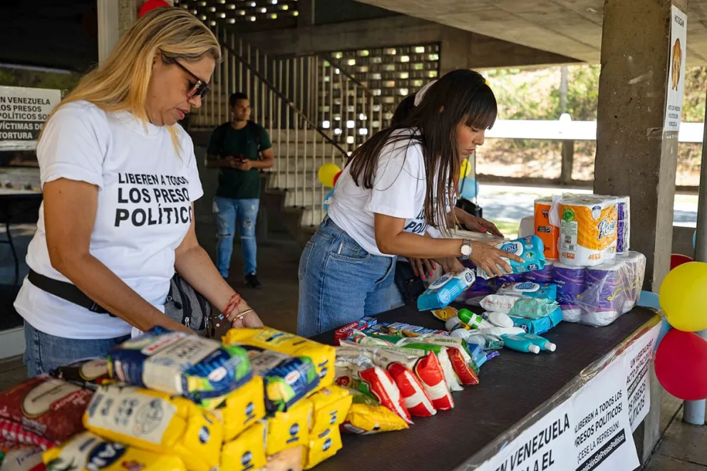 Personas organizan donaciones durante una jornada de recolección para familias de presos políticos este sábado, en Caracas. Foto: EFE