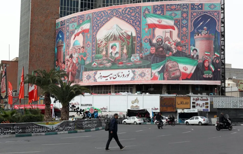Un iraní pasa frente a un enorme cartel en la Plaza Valise de Teherán, Irán, el domingo 22 de marzo de 2026. Foto: EFE