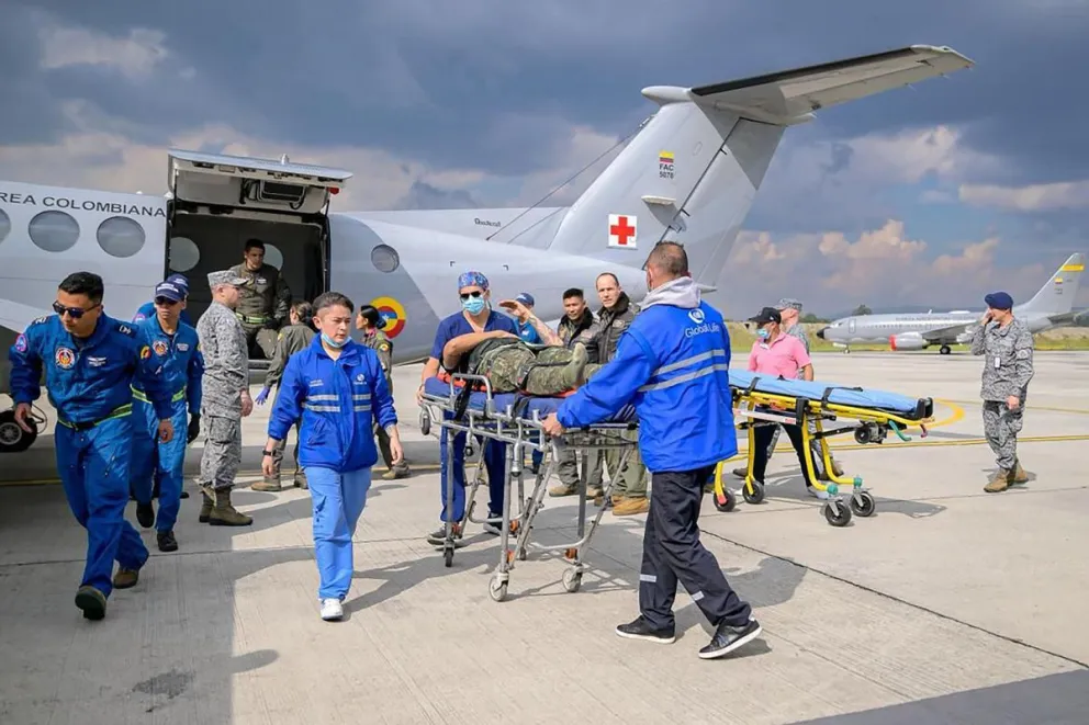 Fotografía cedida por las Fuerzas Militares de Colombia (FF.MM.) que muestra a integrantes de organismos de rescate trasladando un herido de un accidente aéreo este lunes, en el Comando Aéreo de Transporte Militar (CATAM)en Bogotá (Colombia). Foto: EFE