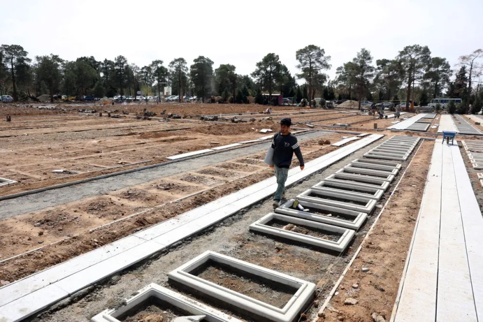 Un trabajador iraní camina sobre las sepulturas preparadas para las víctimas de la guerra de Israel y EEUU contra Irán en el cementerio Behesht Zahra, en el sur de Teherán. Foto: EFE 