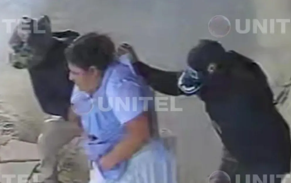 Dos de los sujetos se llevan a la mujer, que se encontraba en un negocio del trópico. Foto: Captura Unitel