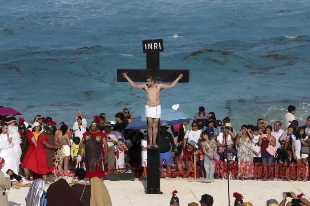 Feligreses representan la pasión y muerte de Cristo durante la XIV edición del viacrucis en una playa, en Cancún (México). Foto: EFE