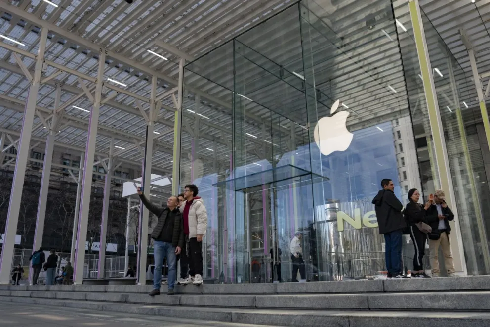 Personas se toman un foto en la entrada de la tienda Apple de la Quinta Avenida este martes en Nueva York. Foto: EFE