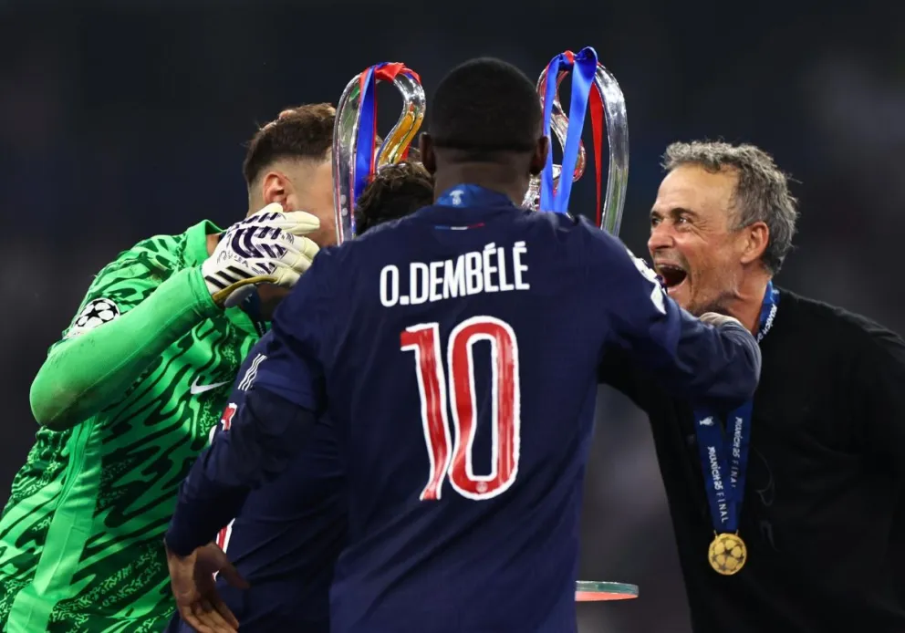Luis Enrique (der.) y Dembelé (centro) celebran tras conquistar la pasada Liga de Campeones. Foto: EFE.