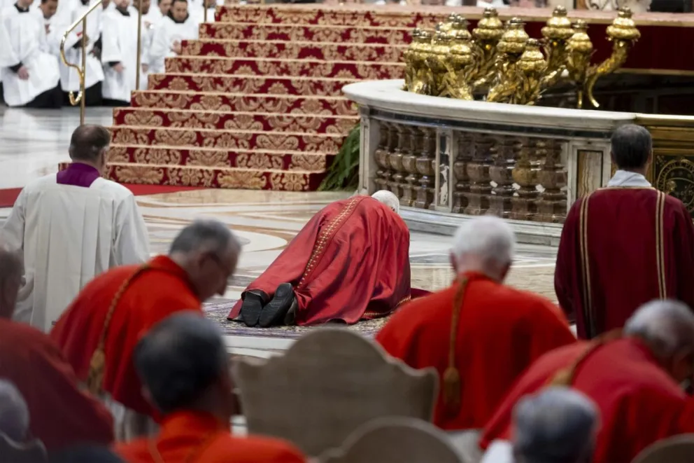 El papa León XIV (C) tendido sobre una alfombra ante el Altar de la Confesión de la basílica de San Pedro del Vaticano durante el rito que conmemora la Pasión de Cristo en el primer Viernes Santo de su pontificado. Foto: EFE