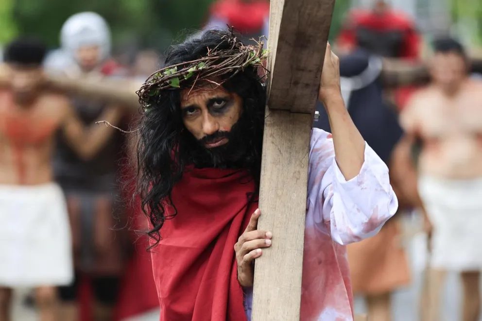 Una persona que representa a Jesús carga una cruz durante el viacrusis de Semana Santa este viernes, en Ciudad de Panamá (Panamá). EFE/ Bienvenido Velasco