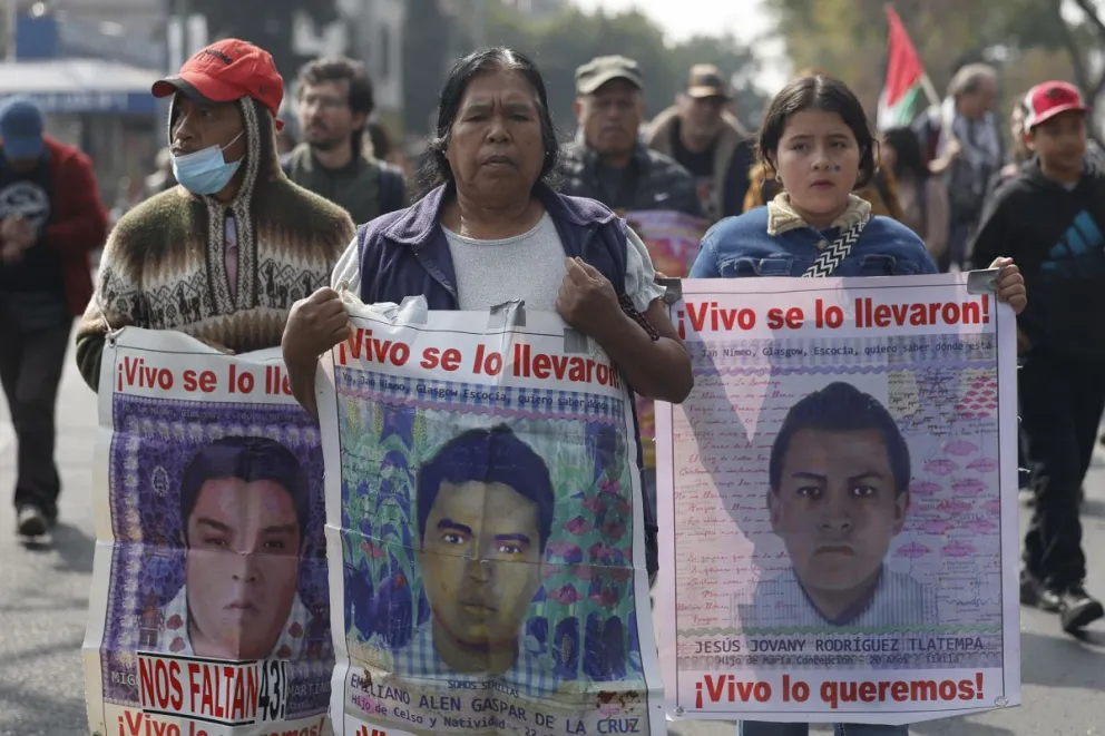 Personas caminan sosteniendo carteles con fotografías durante una peregrinación en Ciudad de México (México). Imagen de archivo. Foto: EFE