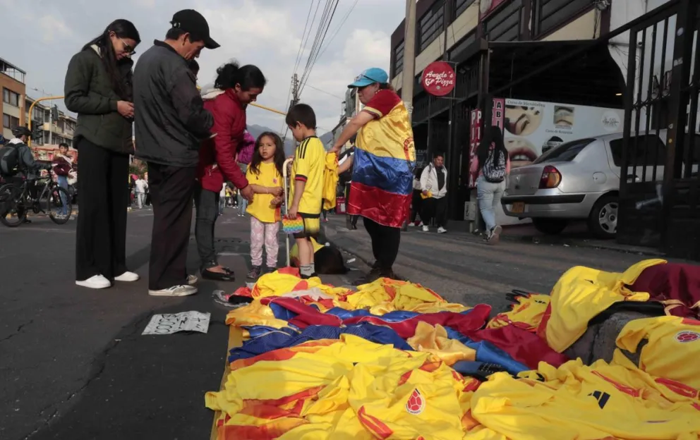Aficionados compran camisetas de Colombia en un puesto callejero. Foto: EFE