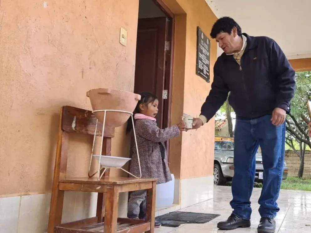 El profesor Wilfredo Gallardo entrega un vaso de agua filtrada a una de sus estudiantes. Foto: Yenny Escalante