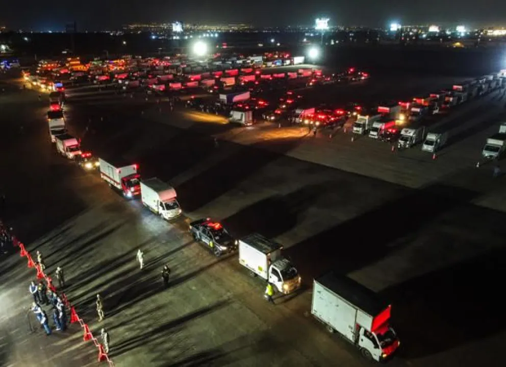 Fotografía aérea que muestra camiones que transportan material electoral hacia los locales de votación en Lima Metropolitana y el Callao en el marco de las elecciones generales de este domingo. EFE