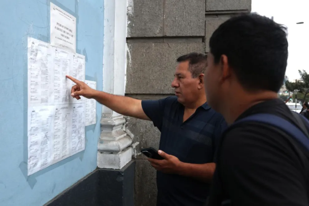 Personas buscan su ligar de votación este domingo, en el colegio Nuestra Señora de Guadalupe en Lima (Perú). Foto: EFE