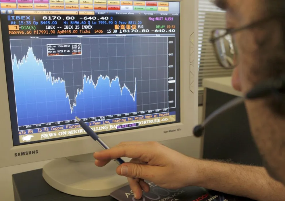 Una persona señala con un bolígrafo en su pantalla de ordenador el comportamiento de un valor del índice Ibex-35 de la Bolsa española. Foto: EFE