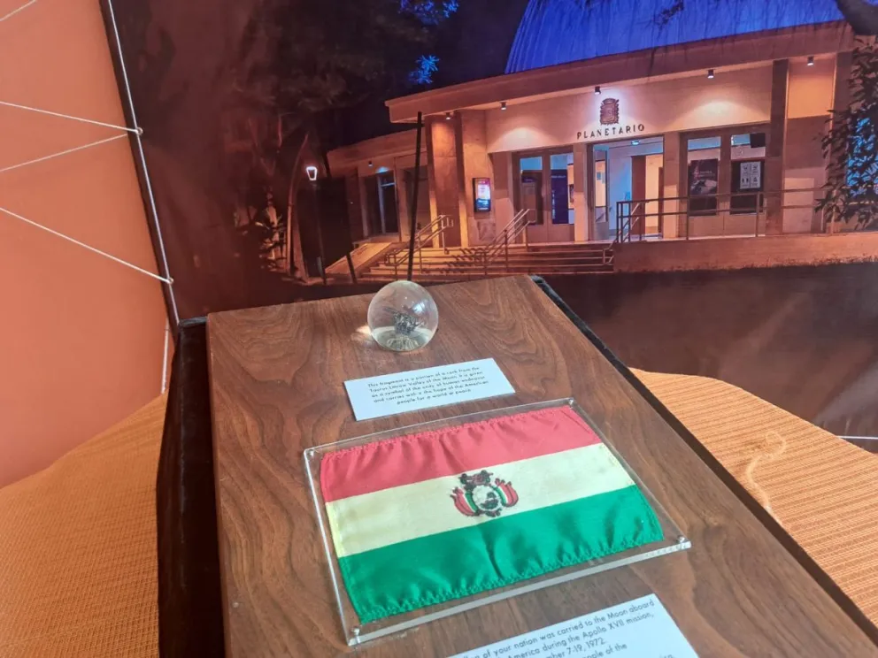 El fragmento lunar, junto a la bandera boliviana que estuvo en el espacio. Foto: Visión 360