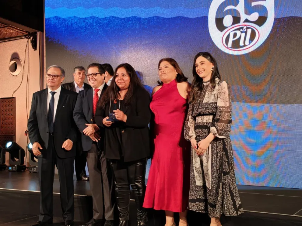 Los gerentes de PIL Bolivia entregan el reconocimiento a la periodista Anahí Cazas, de Visión 360. Foto: Visión 360