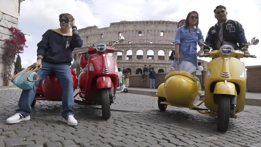 Turistas posan con Vespas en Roma. Foto: EFE