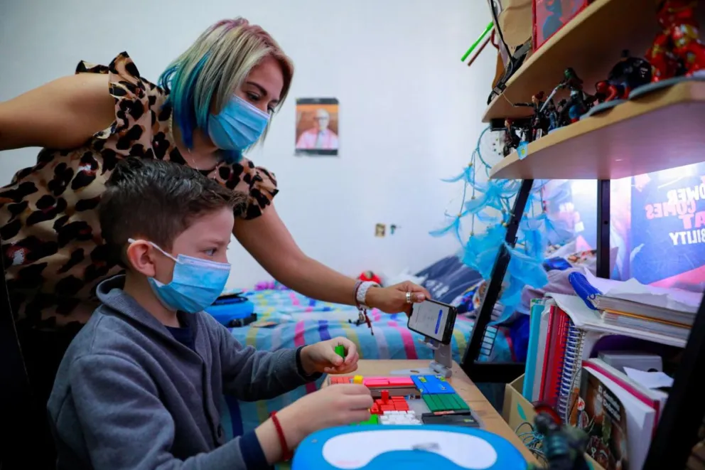Fotografía de archivo que muestra a la señora Marisol Cruz Martínez (i) y su hijo Iñaki estudiando desde casa en Ciudad de México (México). Foto: EFE