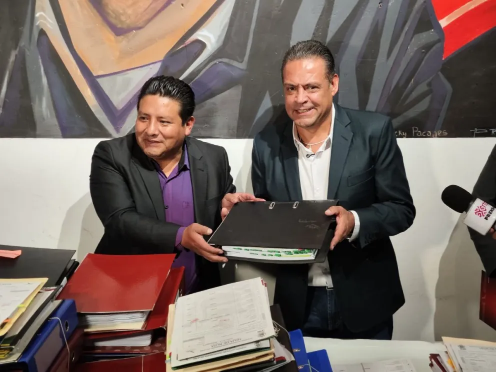 Santos Quispe y Luis Revilla, junto a las carpetas con información de la gestión saliente. Foto: Paulo Lizárraga A.