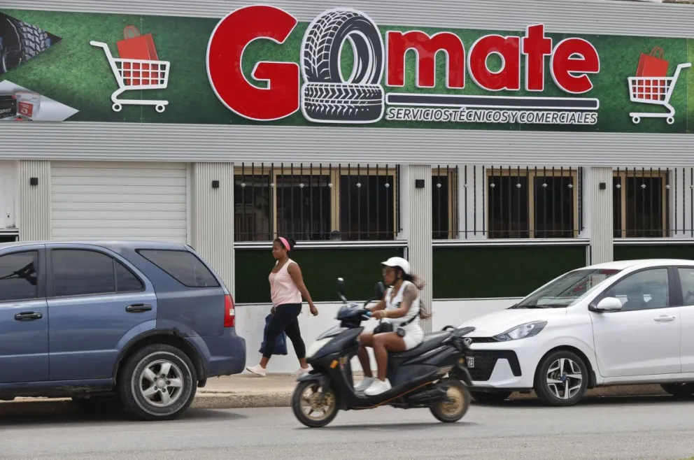 Personas pasan frente al local comercial Gomate este martes en La Habana (Cuba). EFE/Ernesto Mastrascusa
