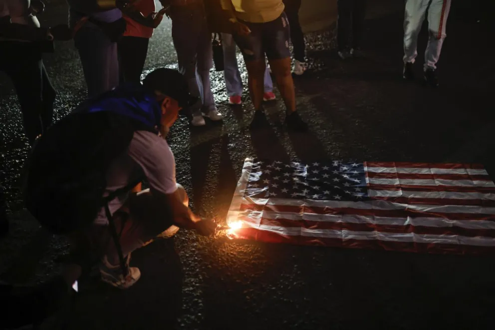 Fotografía de archivo, tomada en junio de 2025, de un ciudadano al quemar una bandera de Estados Unidos. Foto: EFE