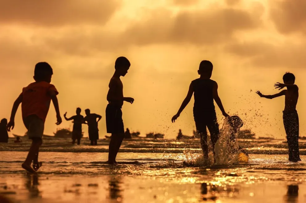 Jóvenes refrescándose en el agua ante la ola de calor en la playa de Gorai. Foto: EFE