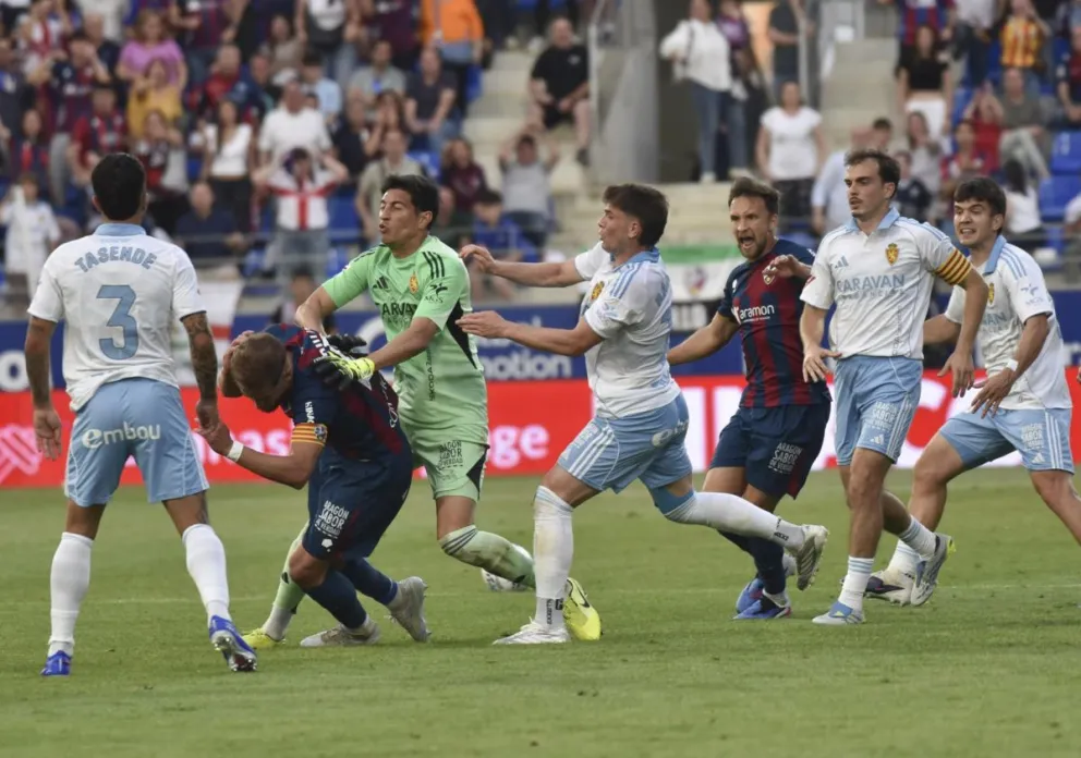 El argentino Esteban Andrada (de verde), portero del Zaragoza, le da un puñetazo al capitán del Huesca Jorge Pulido. Foto: EFE