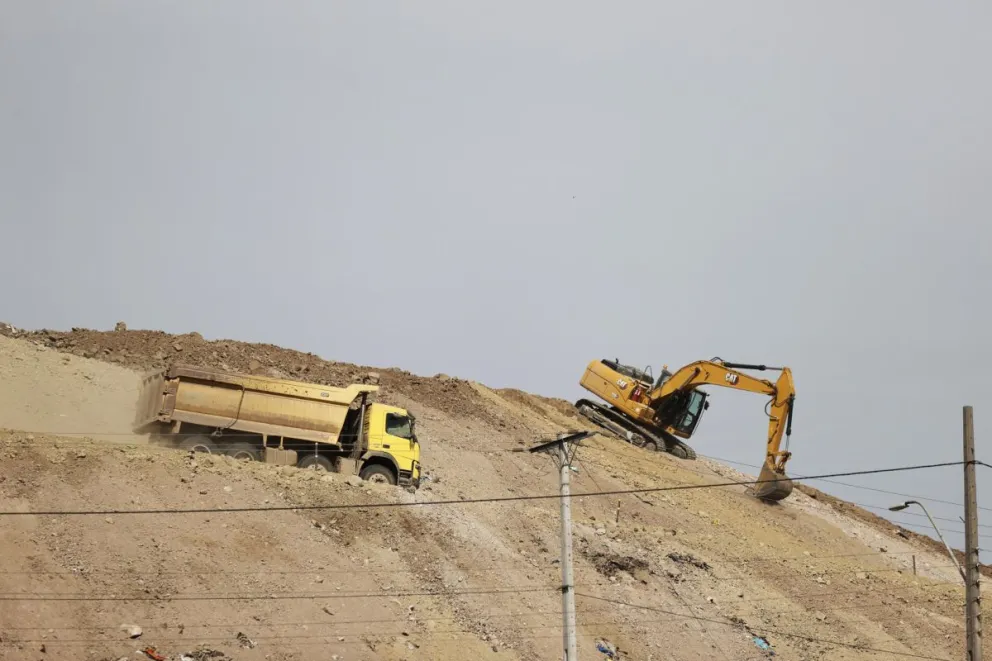 Fotografía que muestra una máquina excavadora y un camón recolector de basura en el relleno sanitario Loma Los Colorados este lunes, en la comuna de Tiltil, en Santiago (Chile). Foto: EFE