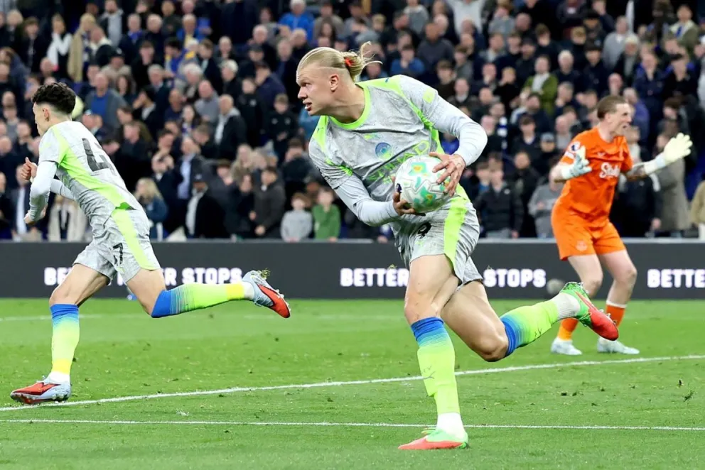 Erling Haaland (centro), jugador del City, agarra el balón para sacar rápido durante el partido ante Everton. Foto: EFE