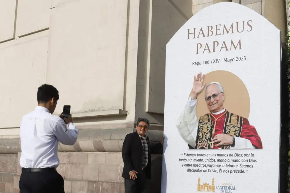 Personas se toman fotografías al lado de una imagen de León XIV en la catedral de Lima al día siguiente de su elección como papa. Foto: EFE/Renato Pajuelo
