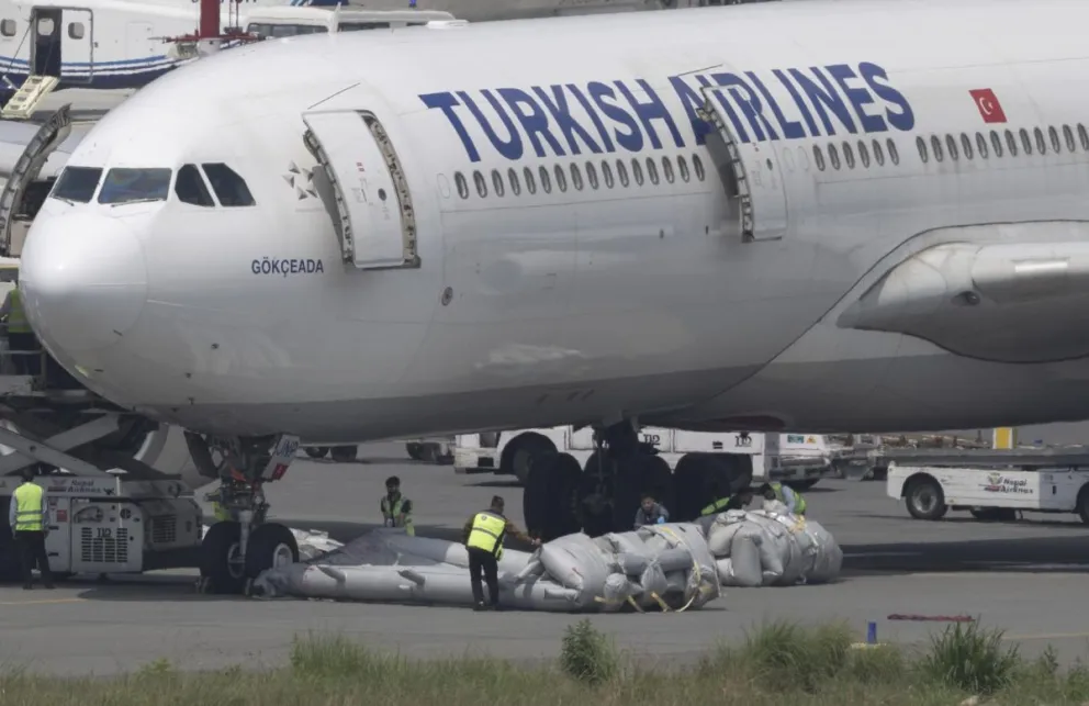 Personal de tierra retira una escalera de emergencia de un avión de Turkish Airlines tras un incendio en el tren de aterrizaje en el Aeropuerto Internacional Tribhuvan de Katmandú, Nepal, el 11 de mayo de 2026. Foto: EFE 