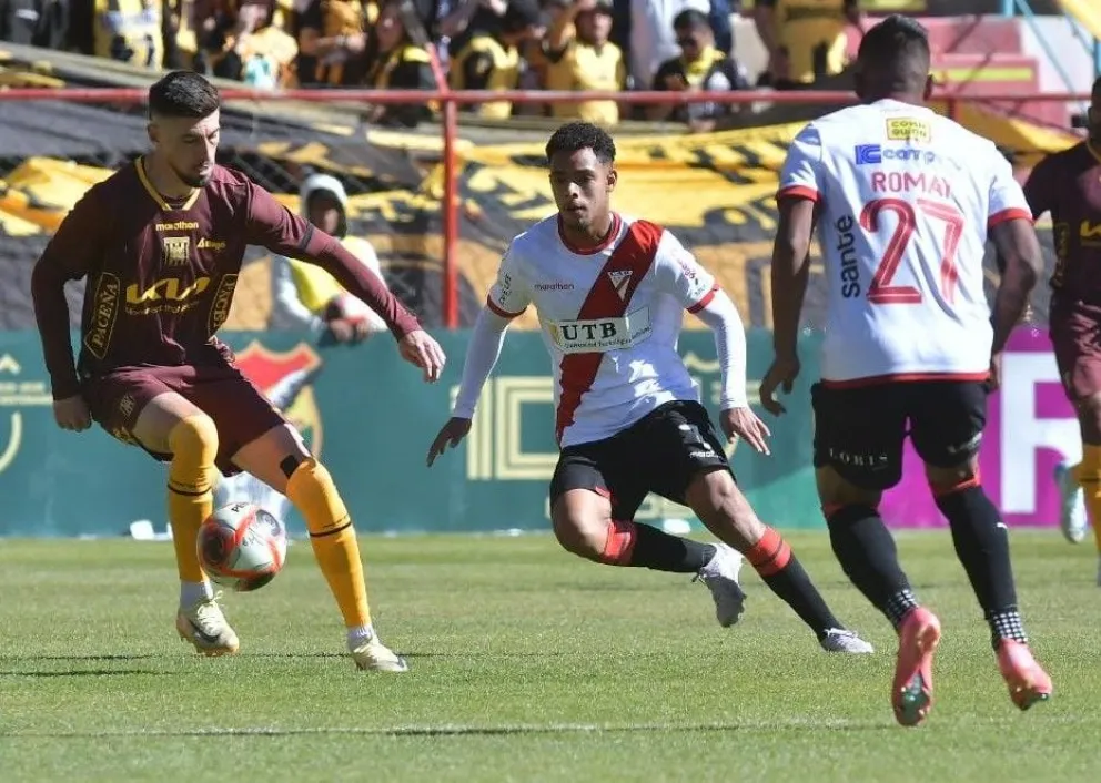 Amoroso (izq.), con la camiseta alterna del Tigre, controla la pelota. Le salen a la marca Paniagua y Romay de Always. Foto: APG