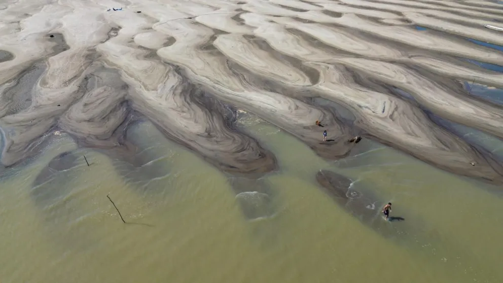 Personas caminando por la arena de la orilla del río Solimões, en la región de Manacapuru, Amazonas (Brasil), en una imagen de archivo. Foto: EFE