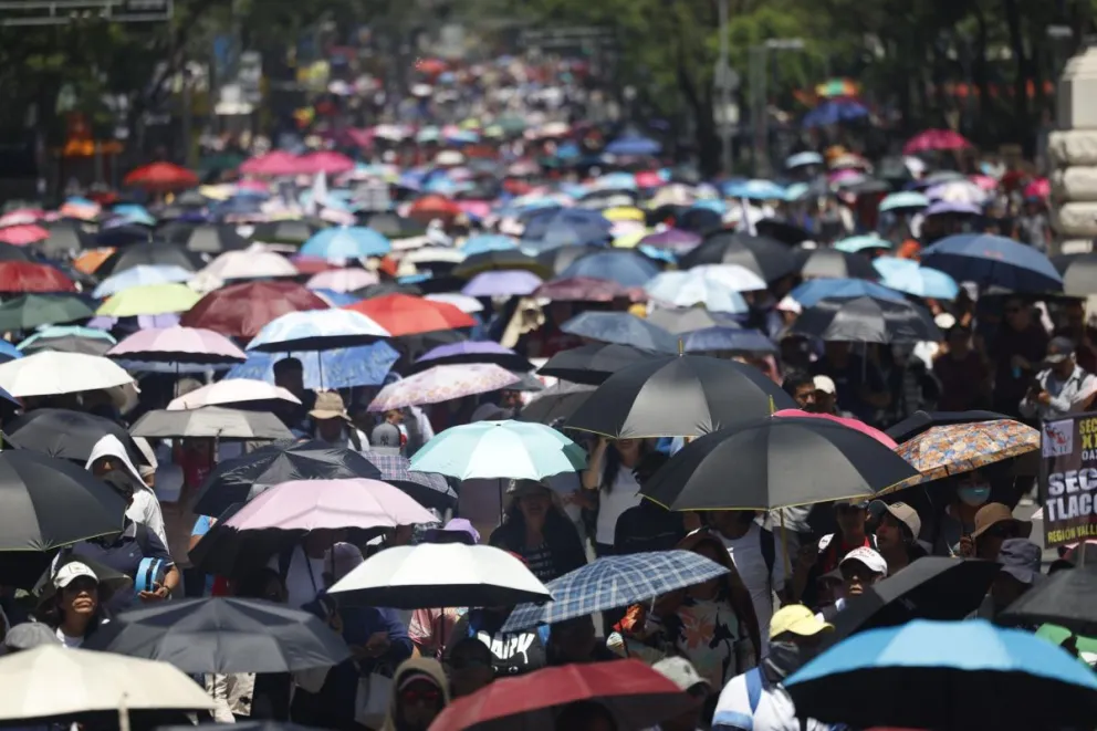 Maestros de la Coordinadora Nacional de Trabajadores de la Educación (CNTE) sostienen sombrillas durante una protesta este viernes, en Ciudad de México (México). Foto: EFE