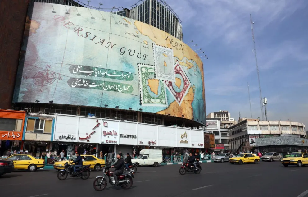 Iraníes pasan por delante de una valla publicitaria que muestra parte del mapa del golfo Pérsico y del estrecho de Ormuz, en Teherán. Foto: EFE