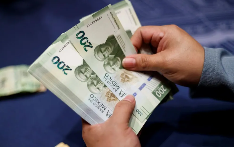 Imagen de archivo cuando una mujer cuenta billetes de 200 pesos en Ciudad de México. Crédito: EFE