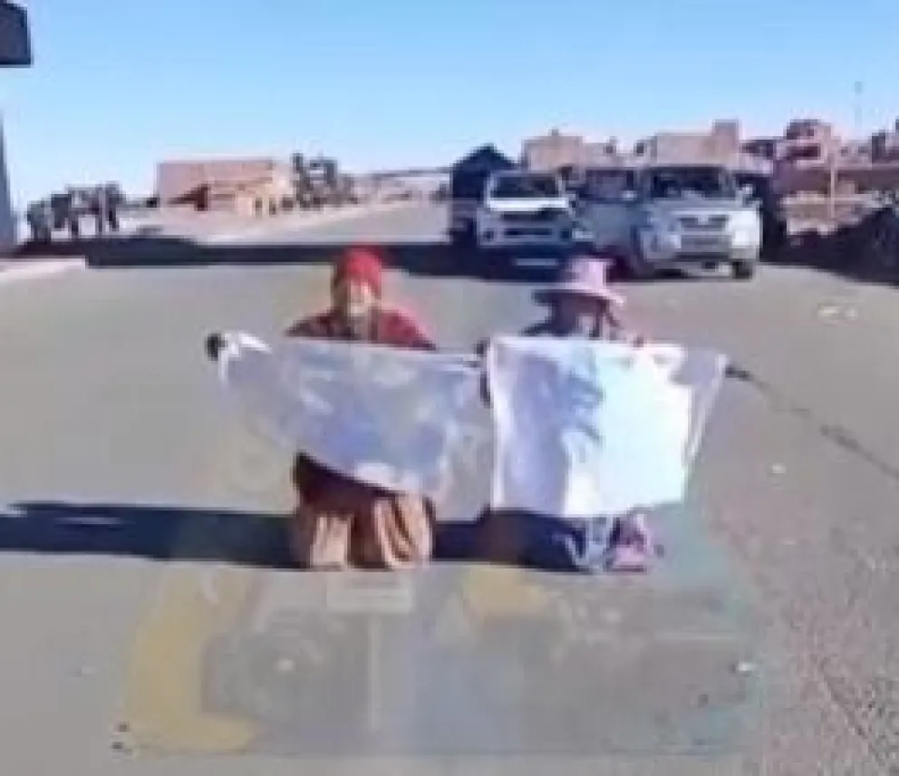 Las dos mujeres de rodillas imploraban paso a los bloqueadores. Foto: Captura de video