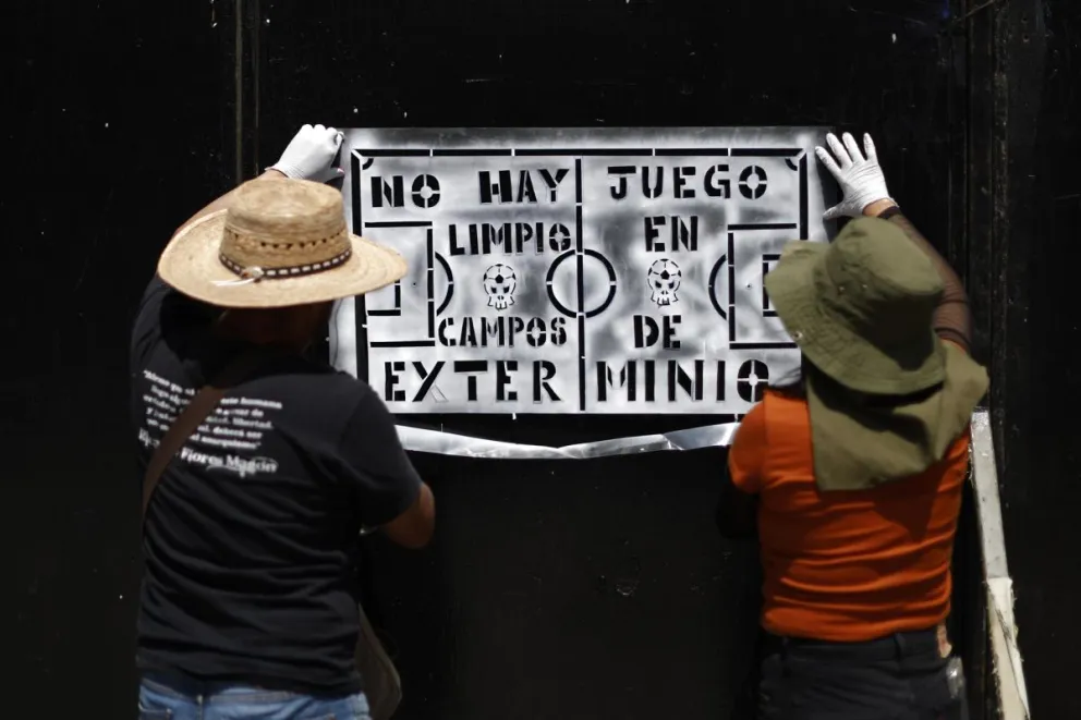 Familiares de personas desaparecidas pegan carteles de protesta este sábado, en Ciudad de México (México). Foto: EFE