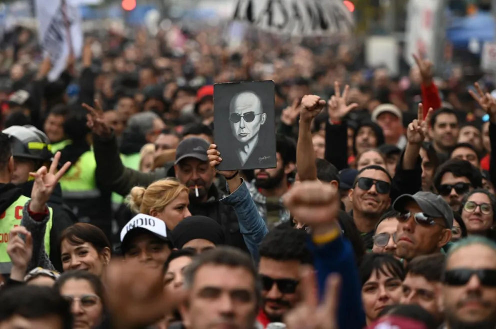 Seguidores del cantante argentino Carlos Alberto 'Indio' Solari sostienes una imagen durante una ceremonia pública para despedir al cantante este domingo, en el Polideportivo Municipal Gatica en Avellaneda (Argentina). Foto: EFE