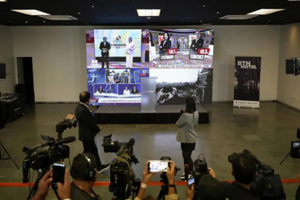 Personas observan una pantalla con los sondeos a pie de urna que muestran un empate técnico entre la derechista Keiko Fujimori y el izquierdista Roberto Sánchez durante la segunda vuelta de las elecciones a la Presidencia de Perú . Foto: EFE