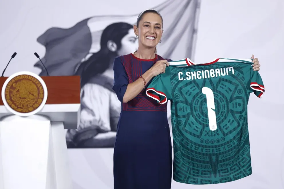 Sheinbaum posa con una camiseta de la selección de México. Foto: EFE.